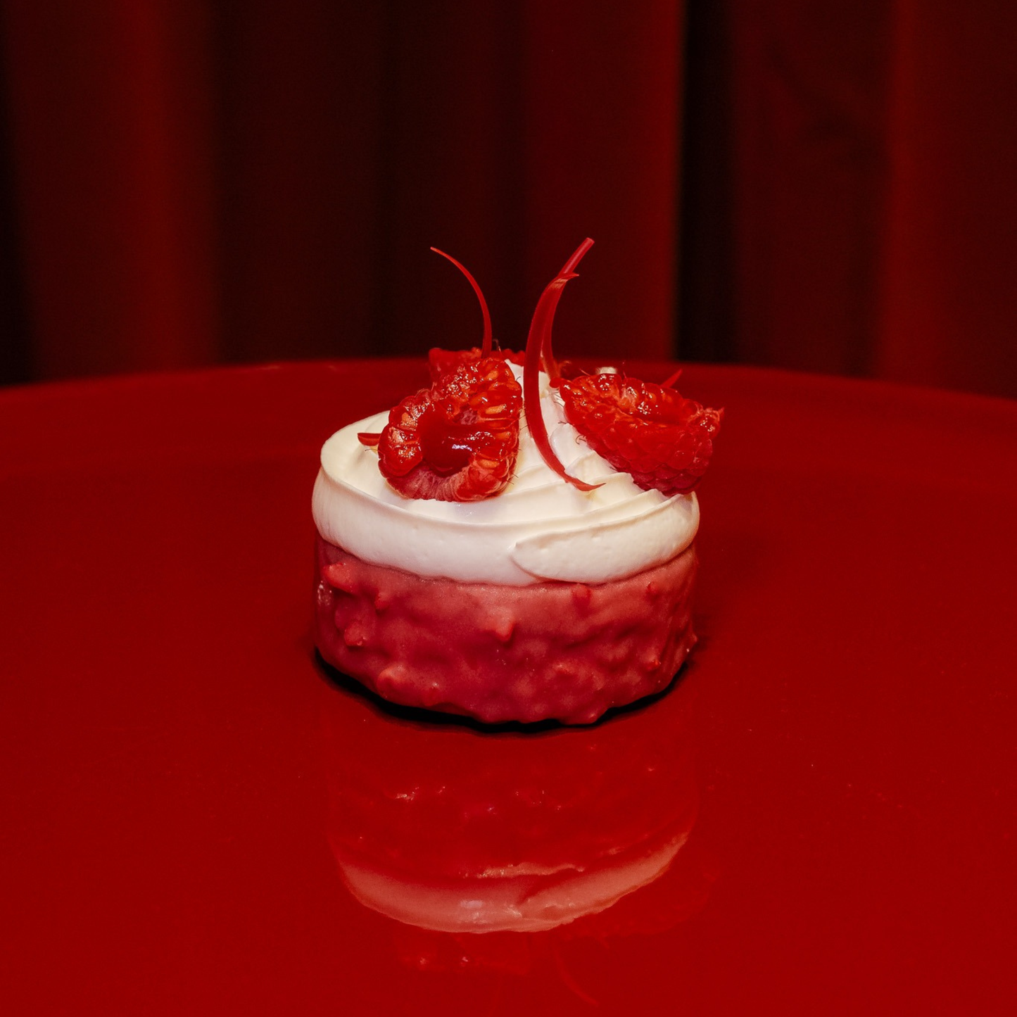Freshly baked raspberry scone topped with smooth cream cheese frosting and fresh raspberries, from Scoff at The Savoy.